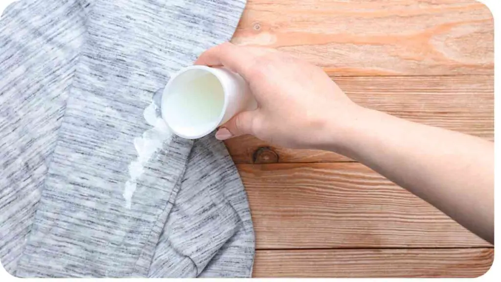 a person holding a cup of liquid on a wooden table
