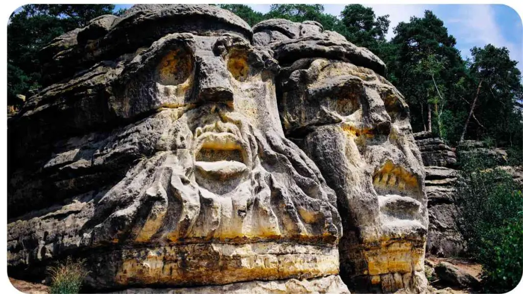 two large rocks with faces on them in the woods