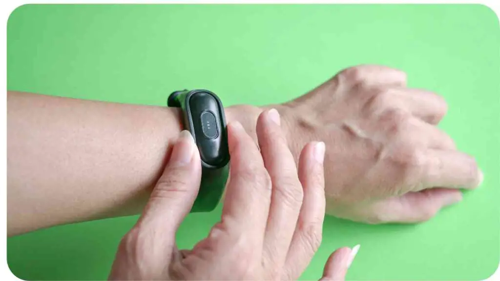 a hand holding a smart watch on a green background